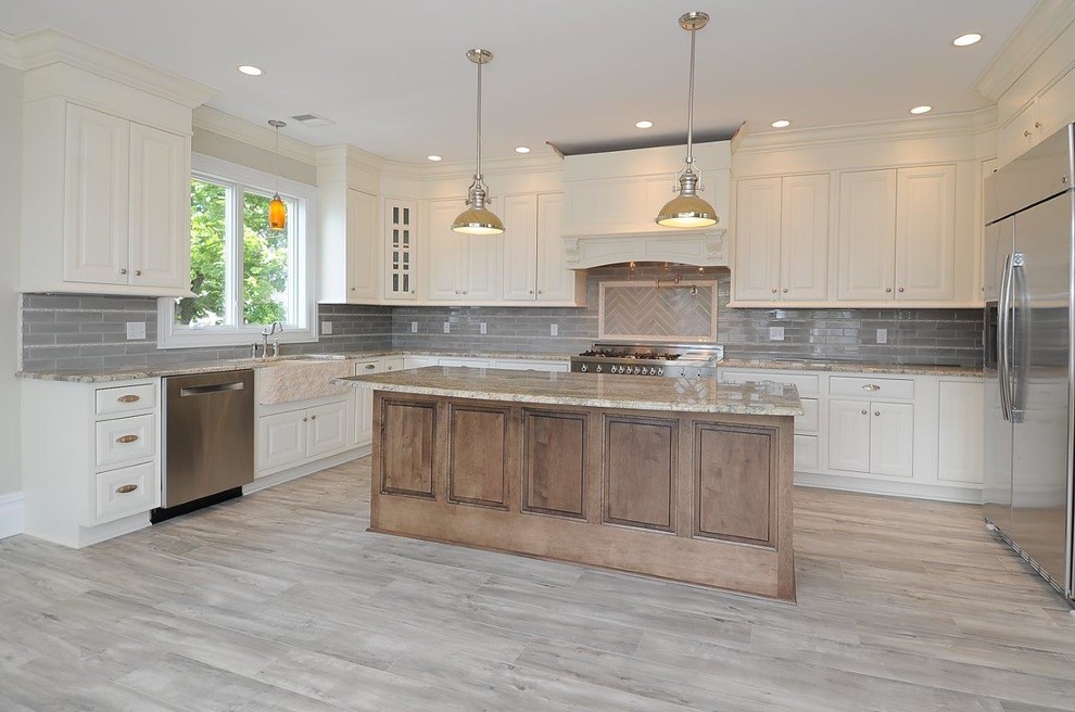 Large transitional u-shaped porcelain tile and gray floor eat-in kitchen photo in New York with an undermount sink, raised-panel cabinets, white cabinets, granite countertops, gray backsplash, subway tile backsplash, stainless steel appliances, an island and white countertops