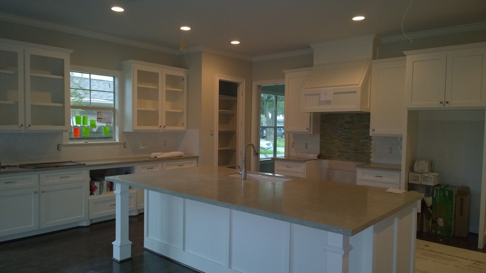 Photo of a medium sized traditional u-shaped open plan kitchen in Houston with recessed-panel cabinets, white cabinets, limestone worktops, stainless steel appliances, dark hardwood flooring and an island.