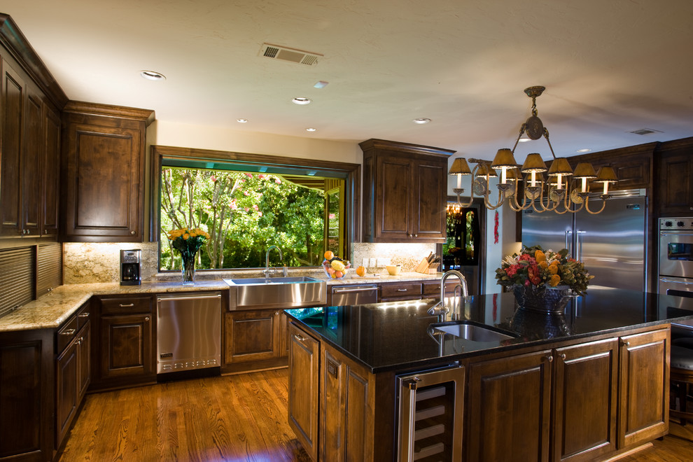 ダラスにあるトラディショナルスタイルのおしゃれなキッチン (エプロンフロントシンク、落し込みパネル扉のキャビネット、濃色木目調キャビネット、無垢フローリング) の写真