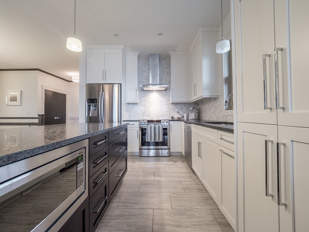 Example of a mid-sized transitional l-shaped vinyl floor and gray floor open concept kitchen design in Edmonton with a double-bowl sink, recessed-panel cabinets, white cabinets, granite countertops, multicolored backsplash, mosaic tile backsplash, stainless steel appliances and an island