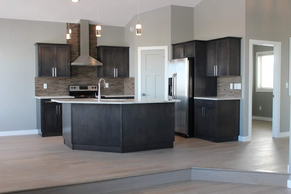 Inspiration for a mid-sized transitional l-shaped light wood floor and gray floor eat-in kitchen remodel in Edmonton with a double-bowl sink, recessed-panel cabinets, brown cabinets, quartzite countertops, brown backsplash, mosaic tile backsplash, stainless steel appliances and an island