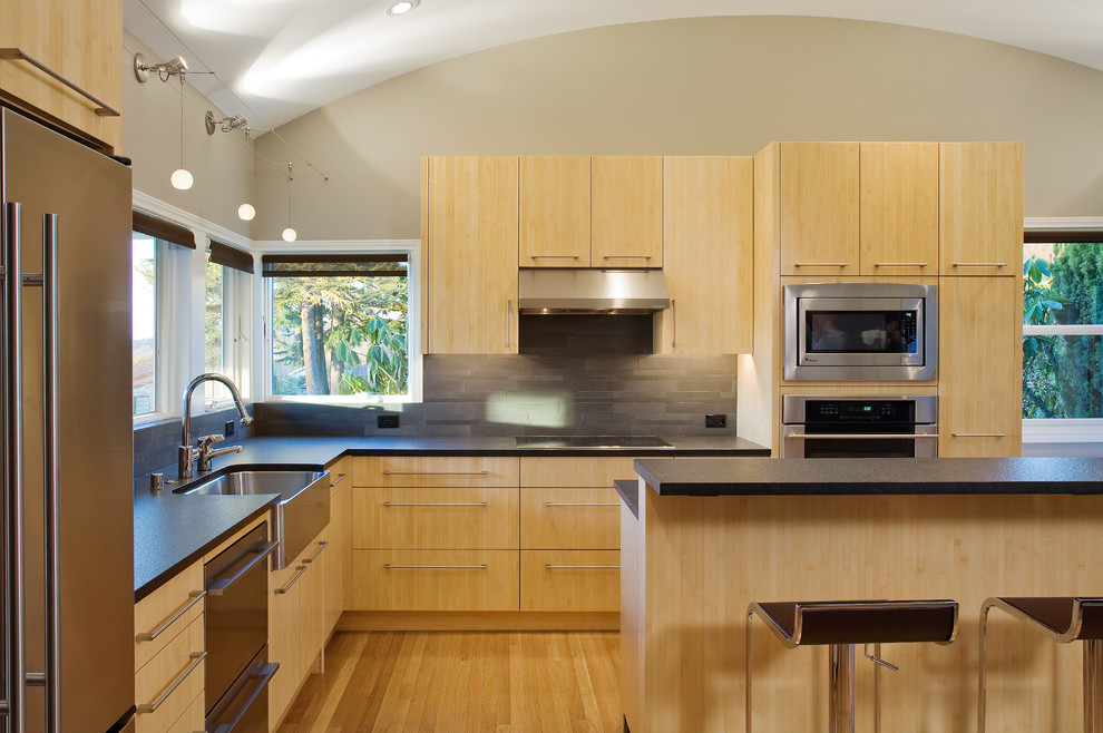 Imagen de cocina contemporánea con electrodomésticos de acero inoxidable y barras de cocina