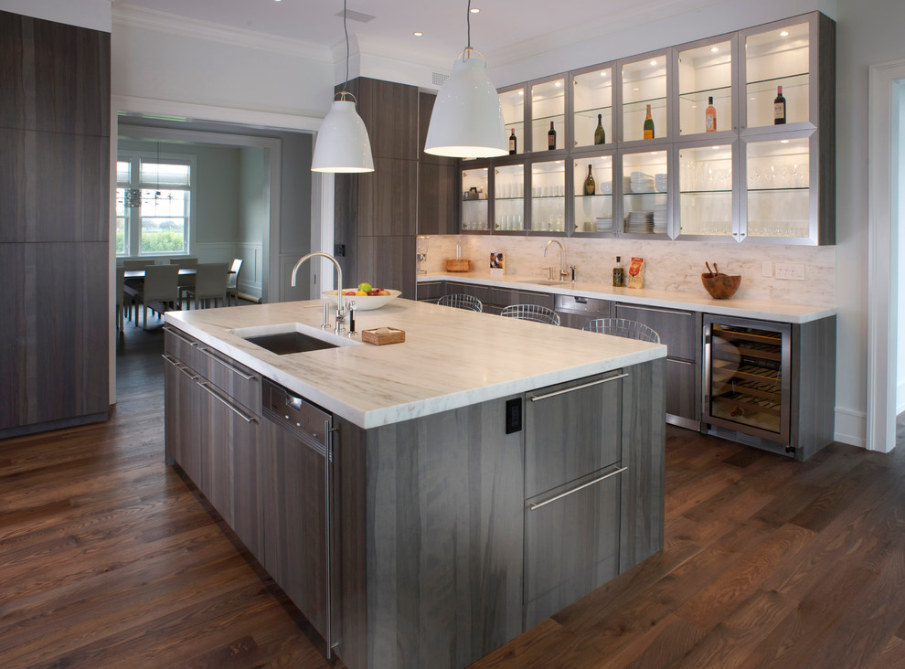 This is an example of a contemporary kitchen in New York with glass-front cabinets, grey cabinets, white splashback, stone slab splashback, dark hardwood flooring and brown floors.