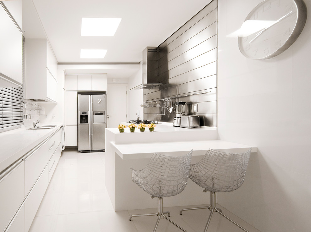 Kitchen in Other with metallic splashback, metal splashback, flat-panel cabinets and white cabinets.