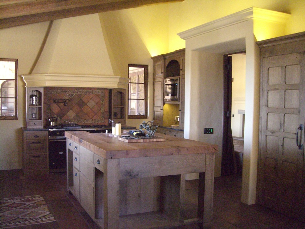 Inredning av ett medelhavsstil mellanstort kök, med en rustik diskho, luckor med profilerade fronter, skåp i ljust trä, träbänkskiva, flerfärgad stänkskydd, stänkskydd i terrakottakakel, integrerade vitvaror, klinkergolv i terrakotta och en köksö