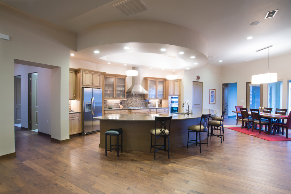 Offene, Einzeilige, Mittelgroße Moderne Küche mit Unterbauwaschbecken, Glasfronten, hellen Holzschränken, bunter Rückwand, Küchengeräten aus Edelstahl, Sperrholzboden und Kücheninsel in Albuquerque