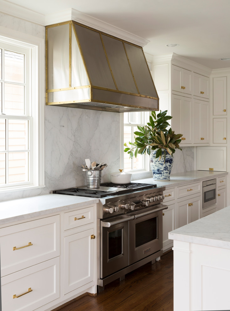 Transitional eat-in kitchen photo in Houston with an undermount sink, shaker cabinets, white cabinets, marble countertops, white backsplash, stone slab backsplash, stainless steel appliances and an island