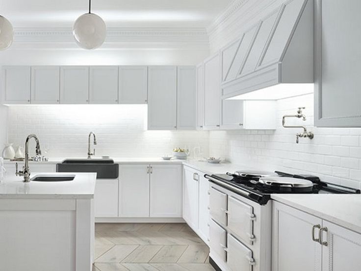 Example of a large transitional l-shaped ceramic tile kitchen pantry design in Austin with an undermount sink, recessed-panel cabinets, white cabinets, solid surface countertops, white backsplash, subway tile backsplash, white appliances and an island