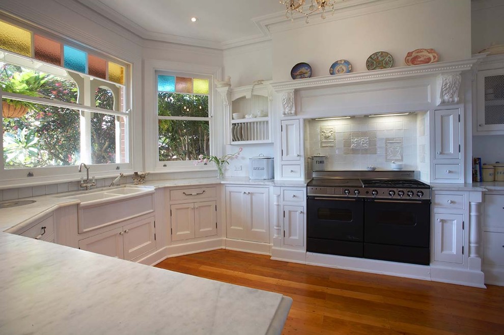 Design ideas for a traditional kitchen in Sydney with a belfast sink and black appliances.
