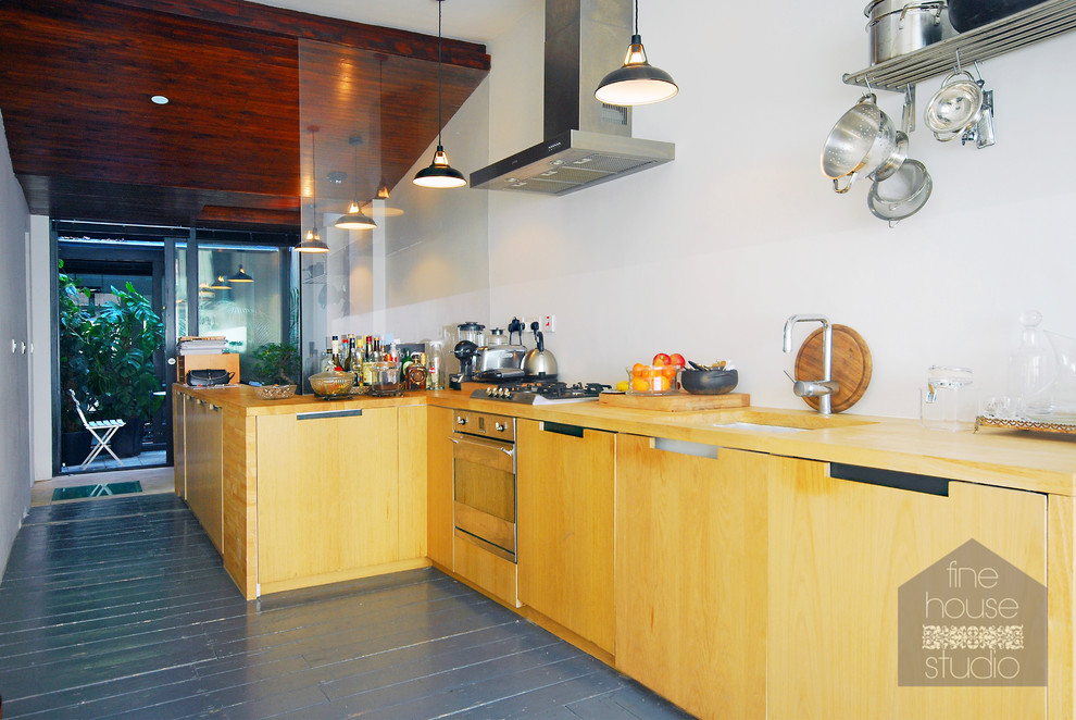 На фото: большая прямая кухня в стиле фьюжн с обеденным столом, врезной мойкой, фасадами цвета дерева среднего тона, деревянной столешницей, техникой под мебельный фасад и деревянным полом