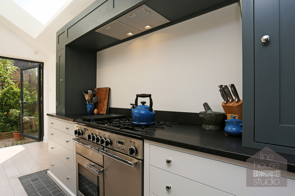 Diseño de cocina comedor actual grande con fregadero sobremueble, puertas de armario grises, suelo de madera clara y una isla