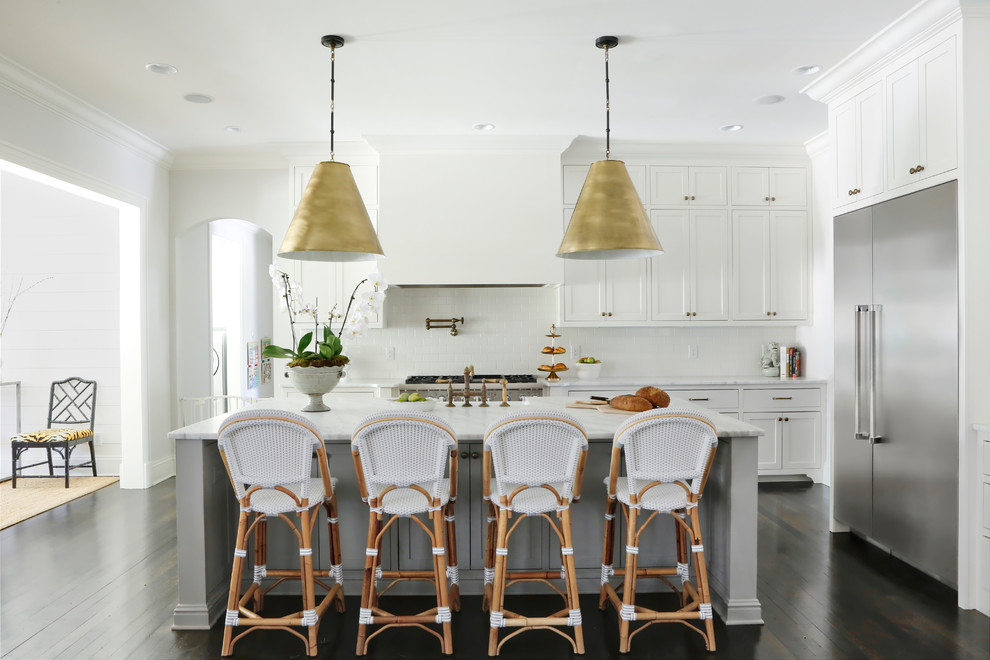 Example of a transitional l-shaped dark wood floor and brown floor kitchen design in Nashville with shaker cabinets, white cabinets, stainless steel appliances and an island