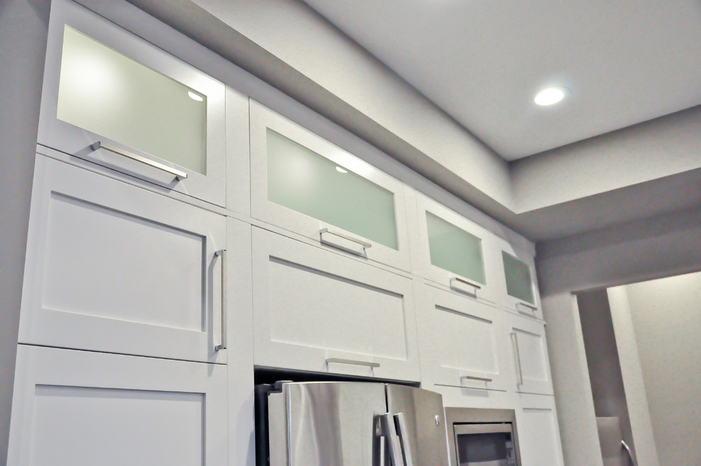 Bild på ett mellanstort funkis linjärt kök och matrum, med luckor med glaspanel, vita skåp, granitbänkskiva, grått stänkskydd, en dubbel diskho, stänkskydd i tunnelbanekakel, rostfria vitvaror, en köksö och grått golv