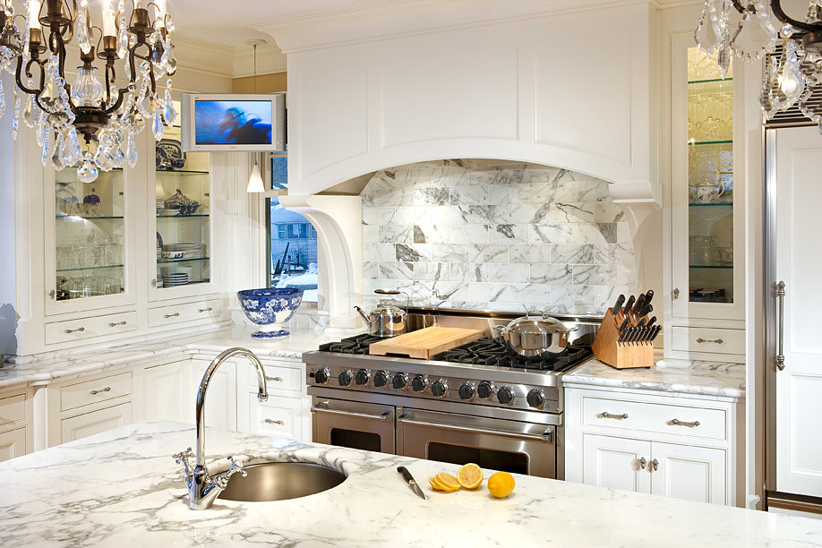 Photo of a classic kitchen in Boston with a submerged sink, recessed-panel cabinets, white cabinets, marble worktops, stone tiled splashback, stainless steel appliances and an island.