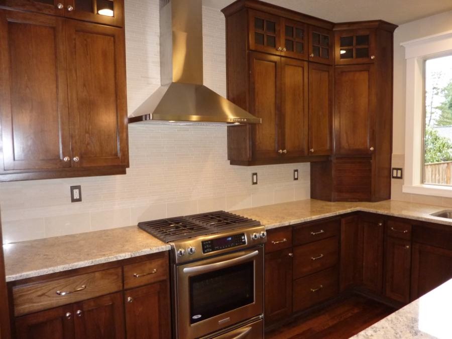 Foto di una grande cucina con ante in legno bruno, top in granito, elettrodomestici in acciaio inossidabile e parquet scuro