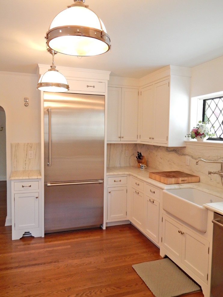 Photo of a medium sized classic enclosed kitchen in New York with a belfast sink, beaded cabinets, white cabinets, marble worktops, white splashback, stainless steel appliances, medium hardwood flooring and no island.