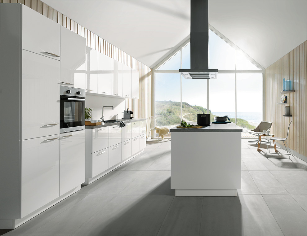 Design ideas for a large coastal u-shaped kitchen/diner in Other with a submerged sink, flat-panel cabinets, white cabinets, concrete worktops, white splashback, stainless steel appliances, concrete flooring and an island.