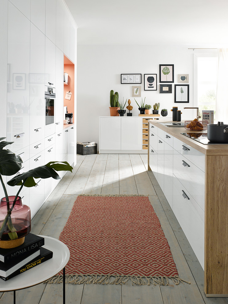 Foto di una piccola cucina design con lavello sottopiano, ante lisce, ante bianche, top in legno, elettrodomestici in acciaio inossidabile e parquet chiaro
