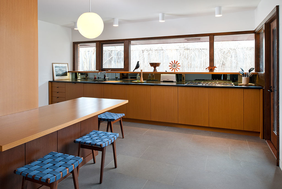 Inspiration pour une cuisine linéaire minimaliste en bois clair avec un placard à porte plane.