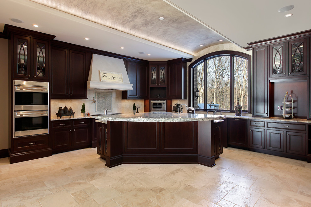Inspiration for a large tropical l-shaped travertine floor eat-in kitchen remodel in Other with recessed-panel cabinets, dark wood cabinets, granite countertops, white backsplash, stone tile backsplash, stainless steel appliances and an island