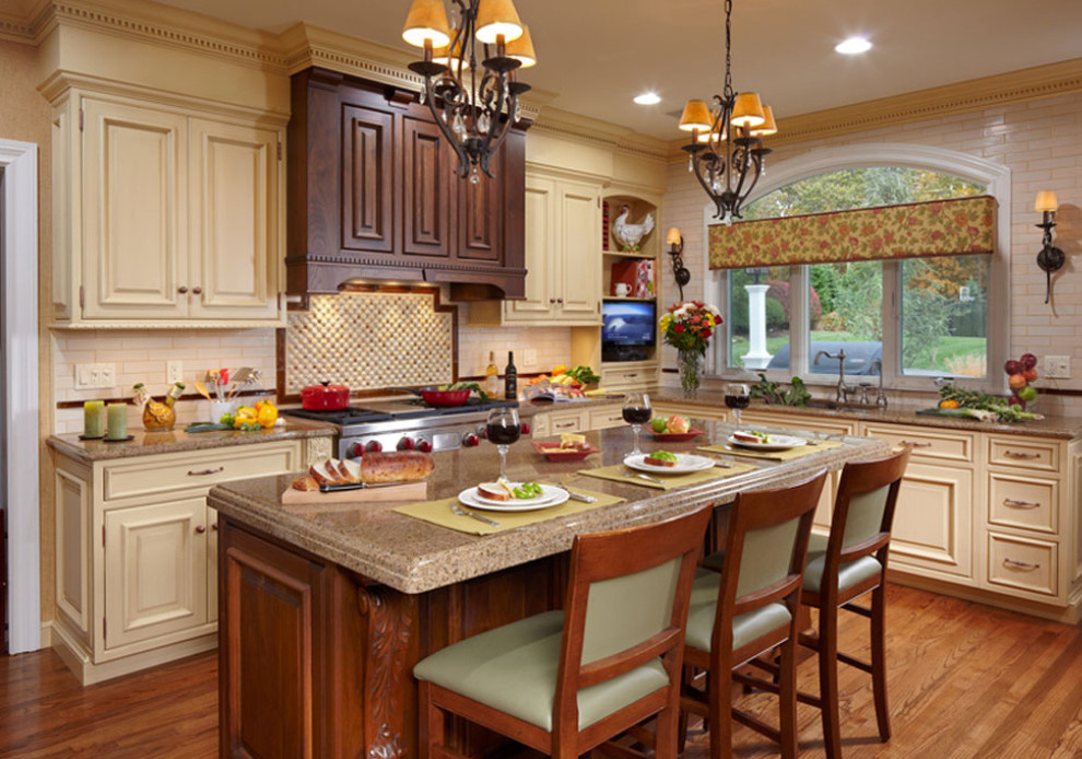 Example of a mid-sized classic l-shaped medium tone wood floor kitchen design in New York with a single-bowl sink, raised-panel cabinets, yellow cabinets, solid surface countertops, yellow backsplash, ceramic backsplash, stainless steel appliances and an island