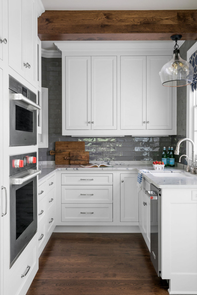 Bild på ett mellanstort vit vitt u-kök, med vita skåp, bänkskiva i kvarts, grått stänkskydd, stänkskydd i keramik, brunt golv, en undermonterad diskho, skåp i shakerstil, rostfria vitvaror och mörkt trägolv