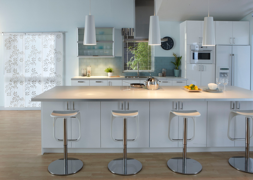 Trendy galley kitchen photo in Other with a drop-in sink, flat-panel cabinets, white cabinets, blue backsplash, subway tile backsplash and white appliances