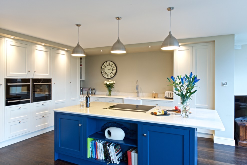 This is an example of a large country l-shaped open plan kitchen in Dublin with recessed-panel cabinets, white cabinets and an island.