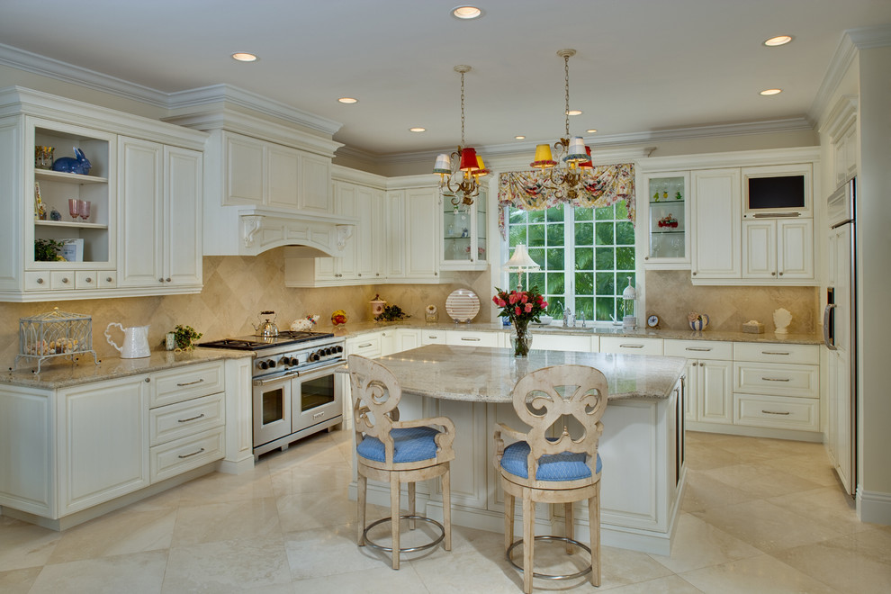 Aménagement d'une grande cuisine américaine encastrable classique en L avec un plan de travail en granite, une crédence beige et îlot.