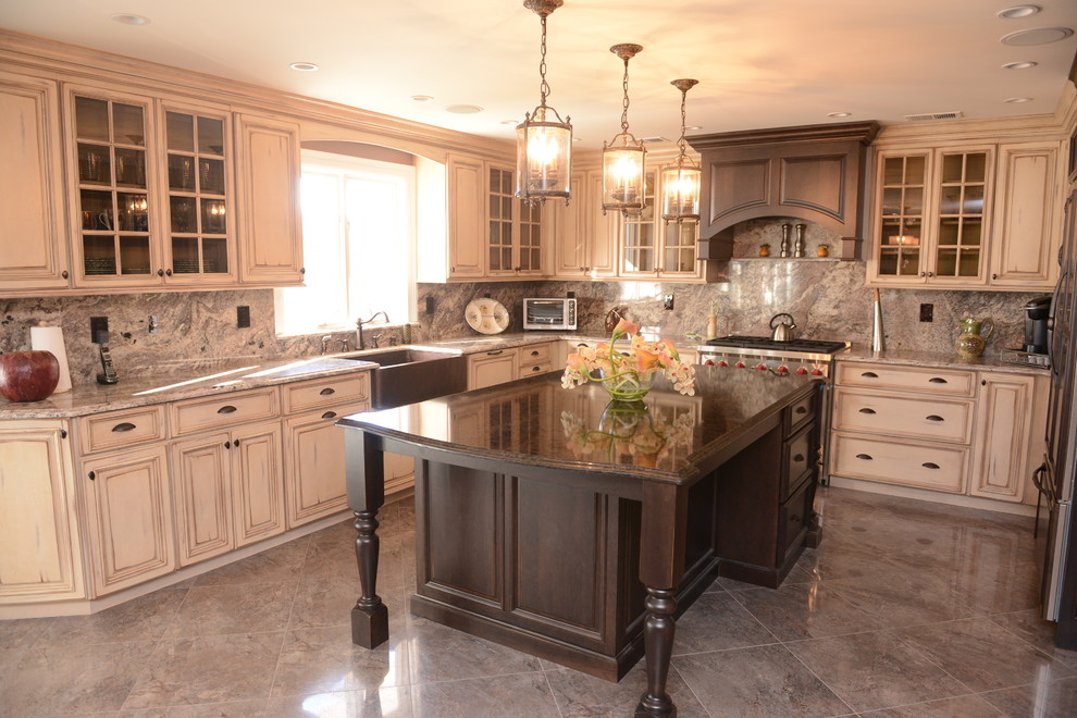 Example of a mid-sized french country u-shaped ceramic tile enclosed kitchen design in New York with a farmhouse sink, raised-panel cabinets, distressed cabinets, granite countertops, multicolored backsplash, stone slab backsplash, stainless steel appliances and an island