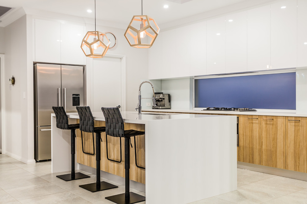 Kitchen - mid-sized contemporary galley porcelain tile kitchen idea in Perth with an undermount sink, white cabinets, solid surface countertops, white backsplash, glass sheet backsplash, stainless steel appliances and an island
