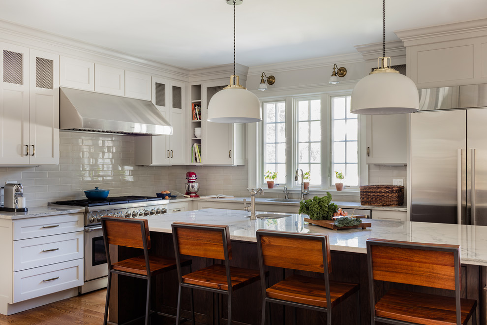 Kitchen - transitional l-shaped kitchen idea in Boston with an undermount sink, shaker cabinets, white cabinets, gray backsplash, subway tile backsplash, stainless steel appliances, an island and quartzite countertops