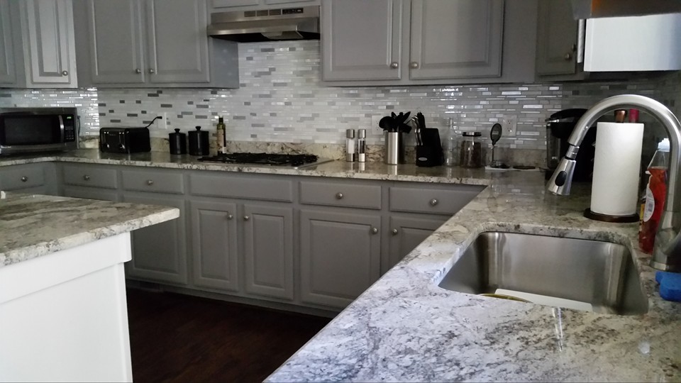 Moderne Küche mit Unterbauwaschbecken, profilierten Schrankfronten, weißen Schränken, Granit-Arbeitsplatte, braunem Boden und weißer Arbeitsplatte in Atlanta