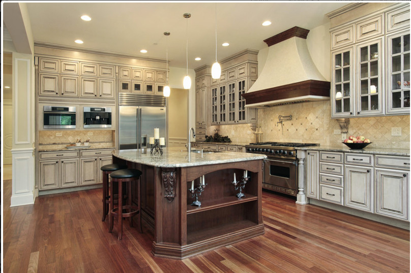 Mid-sized elegant l-shaped dark wood floor and brown floor eat-in kitchen photo in Los Angeles with a double-bowl sink, raised-panel cabinets, distressed cabinets, granite countertops, stainless steel appliances, an island, beige backsplash and ceramic backsplash