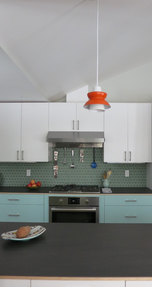 Inspiration for a medium sized retro galley kitchen in New York with a single-bowl sink, flat-panel cabinets, glass worktops and stainless steel appliances.