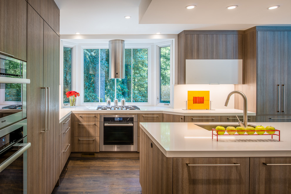 Design ideas for a contemporary l-shaped kitchen in DC Metro with a submerged sink, flat-panel cabinets, medium wood cabinets, white splashback, stainless steel appliances and dark hardwood flooring.