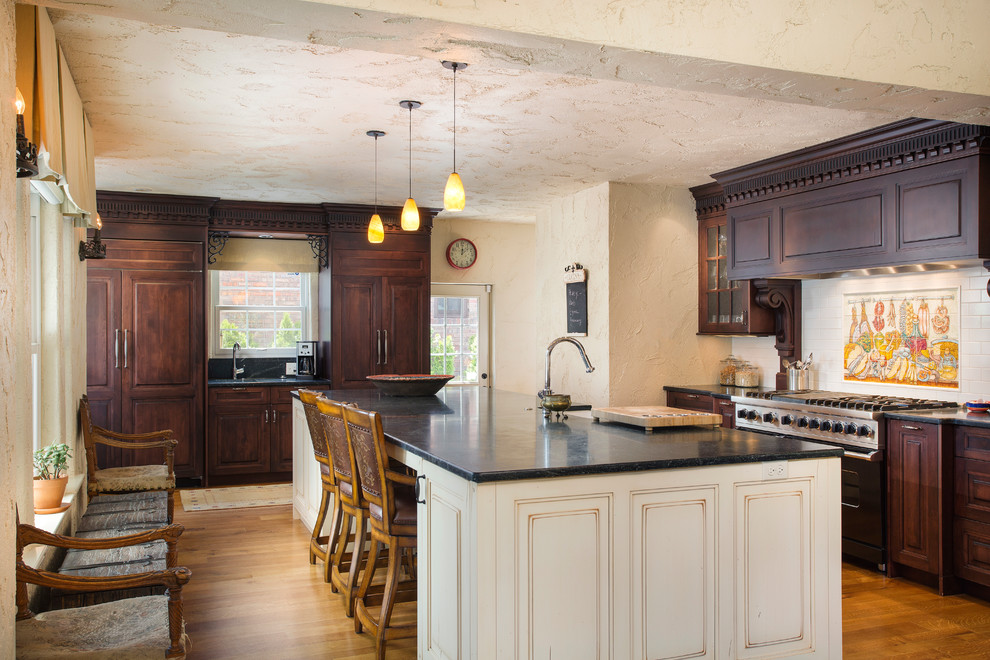 Inspiration for a traditional kitchen in Denver with raised-panel cabinets, dark wood cabinets, medium hardwood flooring and an island.