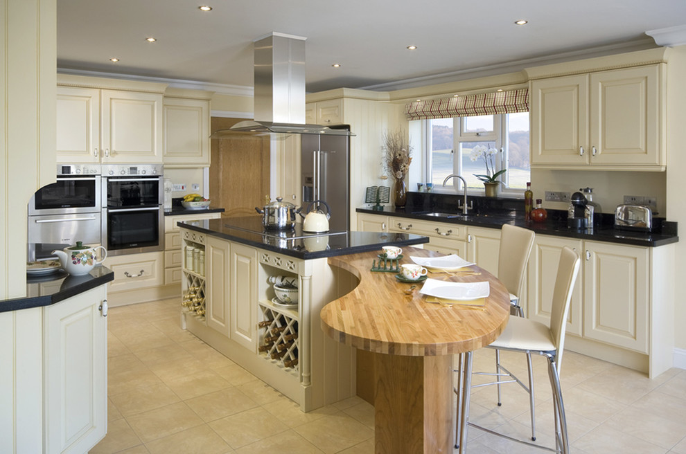 Exempel på ett avskilt klassiskt kök, med en undermonterad diskho, luckor med upphöjd panel, beige skåp och rostfria vitvaror