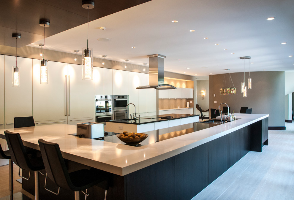 Große Moderne Wohnküche in L-Form mit Doppelwaschbecken, flächenbündigen Schrankfronten, weißen Schränken, Quarzwerkstein-Arbeitsplatte, Küchenrückwand in Weiß, weißen Elektrogeräten, Porzellan-Bodenfliesen und zwei Kücheninseln in Vancouver