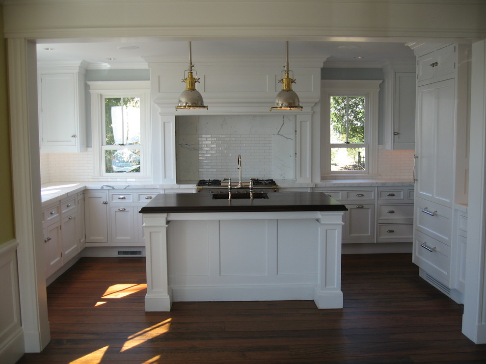 Foto på ett mellanstort vintage kök, med luckor med infälld panel, vita skåp, vitt stänkskydd, stänkskydd i keramik, mörkt trägolv och en köksö