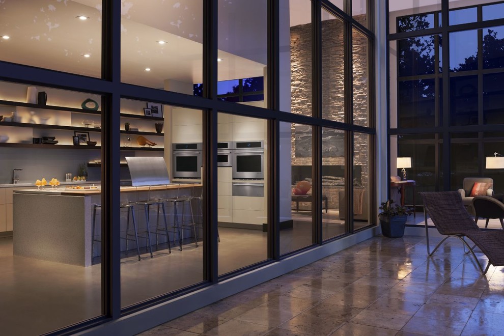 Exempel på ett stort modernt kök med öppen planlösning, med släta luckor, bänkskiva i terrazo, rostfria vitvaror, betonggolv och en köksö