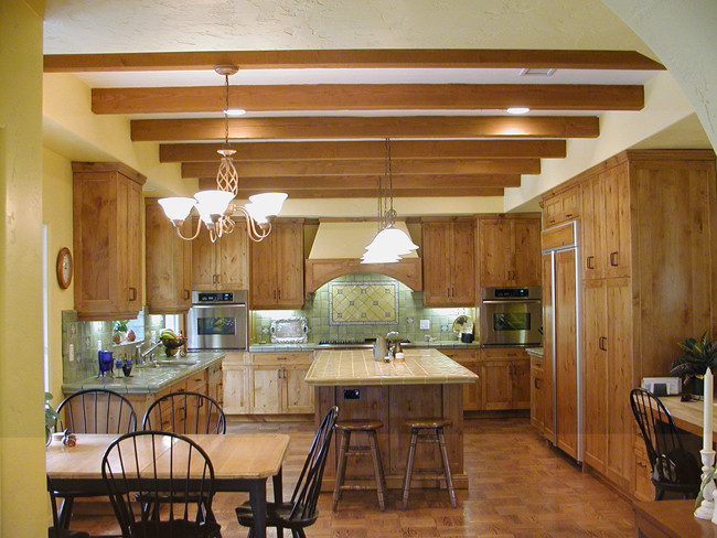 Inspiration for a medium sized traditional u-shaped kitchen/diner in San Diego with a double-bowl sink, recessed-panel cabinets, light wood cabinets, tile countertops, green splashback, ceramic splashback, stainless steel appliances and medium hardwood flooring.
