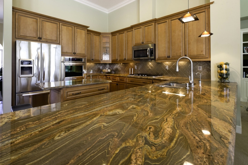 Large l-shaped kitchen photo in Jacksonville with medium tone wood cabinets, marble countertops, beige backsplash, ceramic backsplash, stainless steel appliances and an island