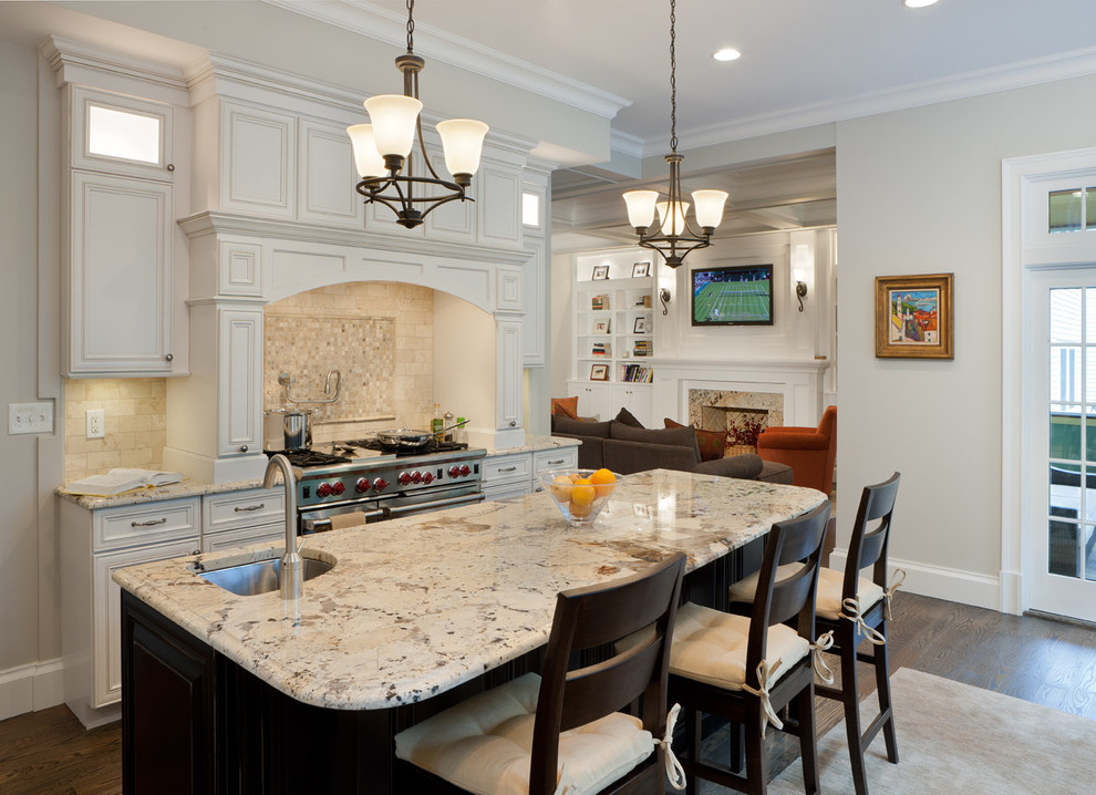 Elegant kitchen photo in Boston with white cabinets, beige backsplash and stainless steel appliances