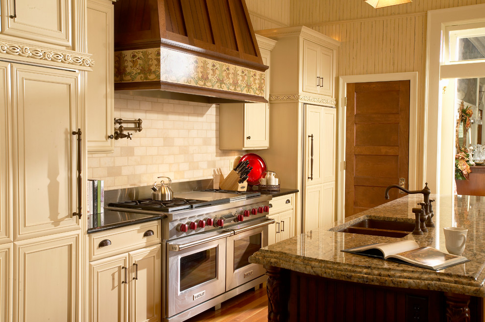 На фото: кухня в классическом стиле с гранитной столешницей и техникой под мебельный фасад с