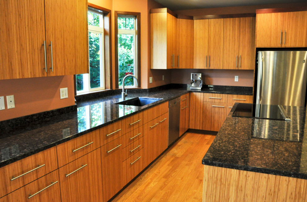 Foto på ett mellanstort orientaliskt l-kök, med en undermonterad diskho, släta luckor, skåp i ljust trä, granitbänkskiva, rostfria vitvaror, mellanmörkt trägolv, en köksö och brunt golv