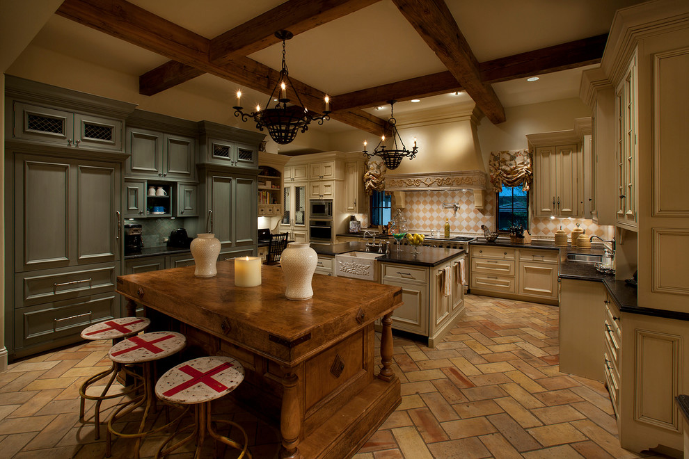 Inspiration for a large mediterranean u-shaped limestone floor eat-in kitchen remodel in Phoenix with two islands, flat-panel cabinets, beige cabinets, granite countertops, multicolored backsplash, paneled appliances and an undermount sink