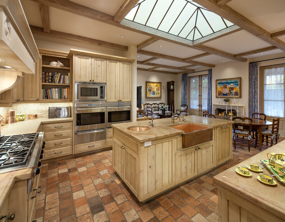 Klassische Wohnküche mit hellen Holzschränken, Küchengeräten aus Edelstahl, Backsteinboden, Kücheninsel, Landhausspüle und Küchenrückwand in Beige in Santa Barbara