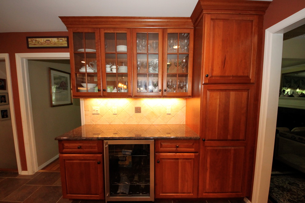 Klassisk inredning av ett avskilt, mellanstort l-kök, med en undermonterad diskho, luckor med upphöjd panel, skåp i mörkt trä, granitbänkskiva, beige stänkskydd, stänkskydd i stenkakel, rostfria vitvaror, klinkergolv i keramik, en köksö och brunt golv