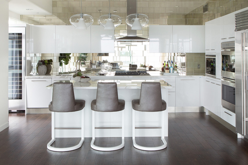 Moderne Küche in L-Form mit flächenbündigen Schrankfronten, weißen Schränken, Küchenrückwand in Metallic und Küchengeräten aus Edelstahl in Los Angeles